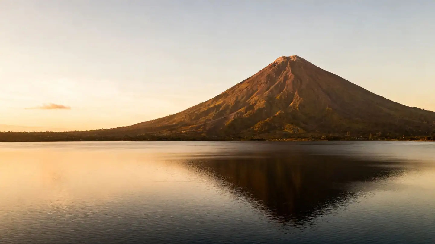 Nicaragua: a volcano across a large calm lake in golden-hour light
