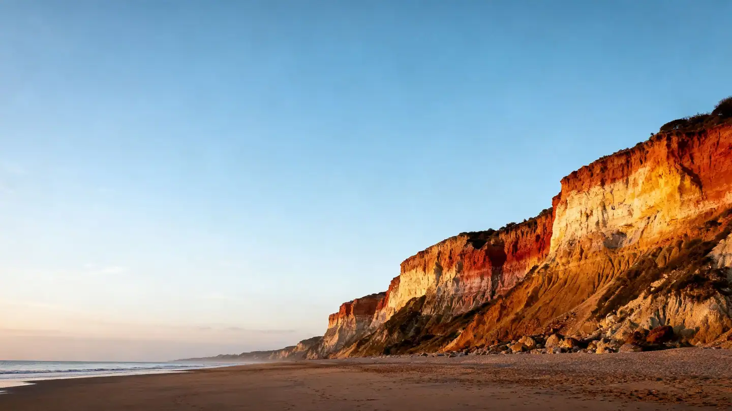 Martha's Vineyard: colorful clay cliffs above a quiet Atlantic beach in golden-hour light