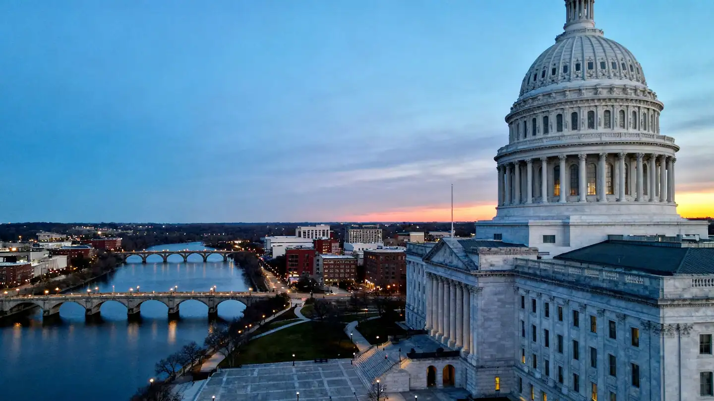 Providence: a calm river through downtown with arched footbridges and a domed white marble capitol at dusk