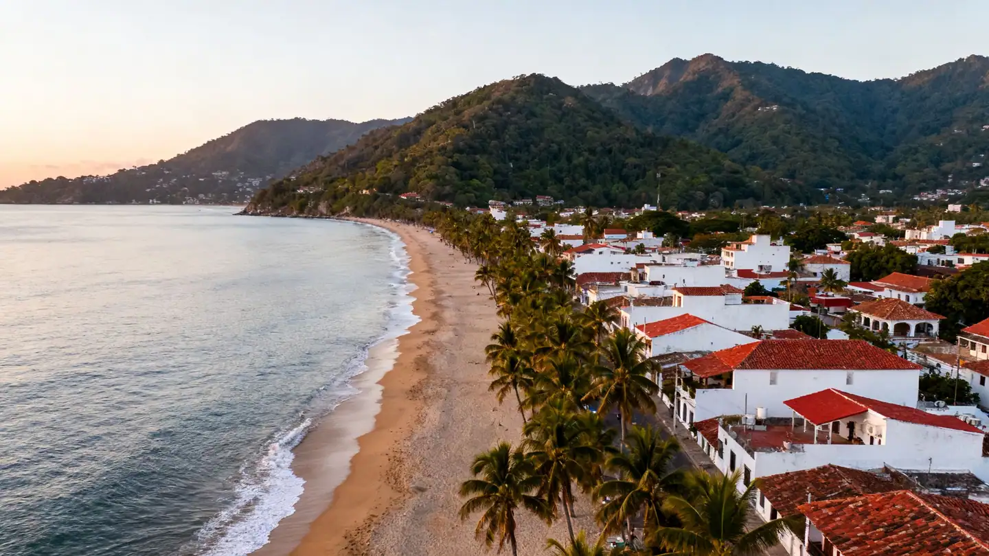 The Bay of Banderas at Puerto Vallarta, Mexico: a wide Pacific bay with a long sandy beach lined with palm trees at sunset