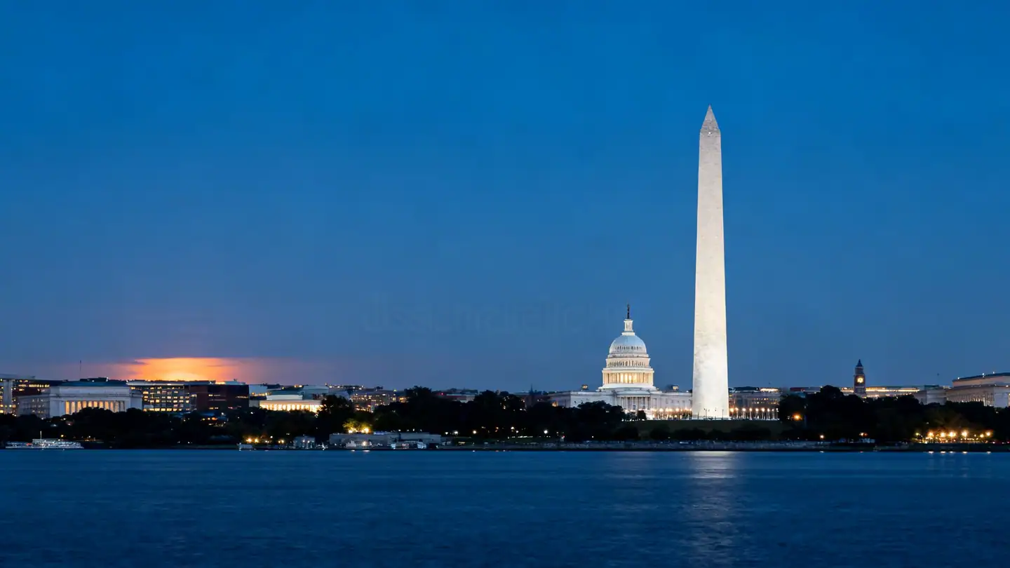 Washington, DC across the Potomac River at dusk: a tall white obelisk monument and a domed capitol-style building on the skyline